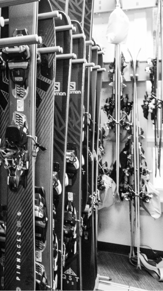 black and white image of skies hanging in rental stalls