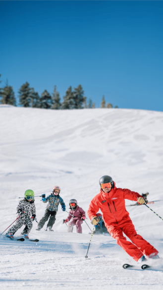 Ski instructor leads lesson of children on snowy slopes at aspen mountain