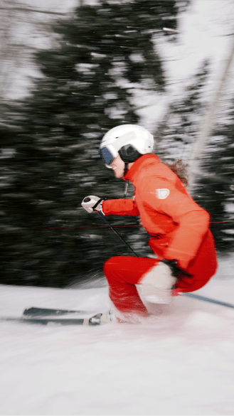 skier in red kit carving on aspen mountain