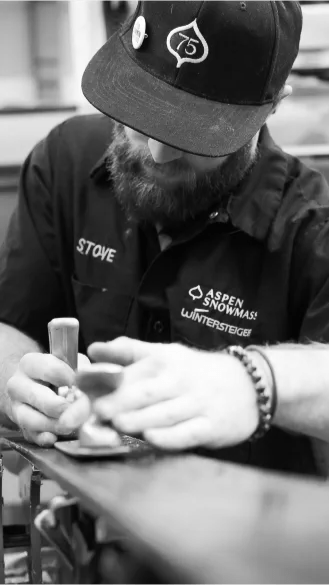black and white image of aspen snowmass employee tuning skies