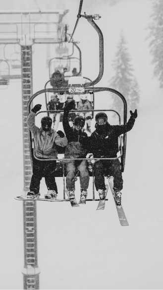 three people wave at the carlift in front of them as they get their picture taken 