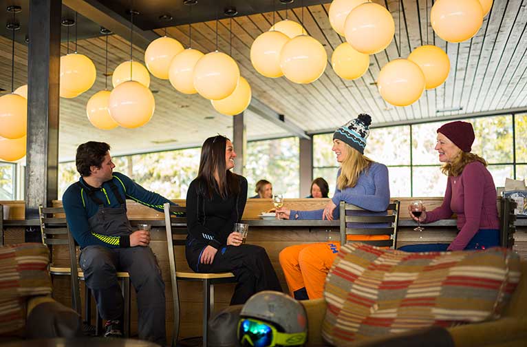 Four guests enjoy drinks at Merry-Go-Round on Aspen Highlands.