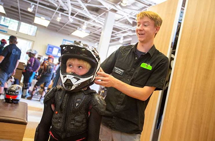 A boy gets fitted for a bike helmet at Four Mountain Sports