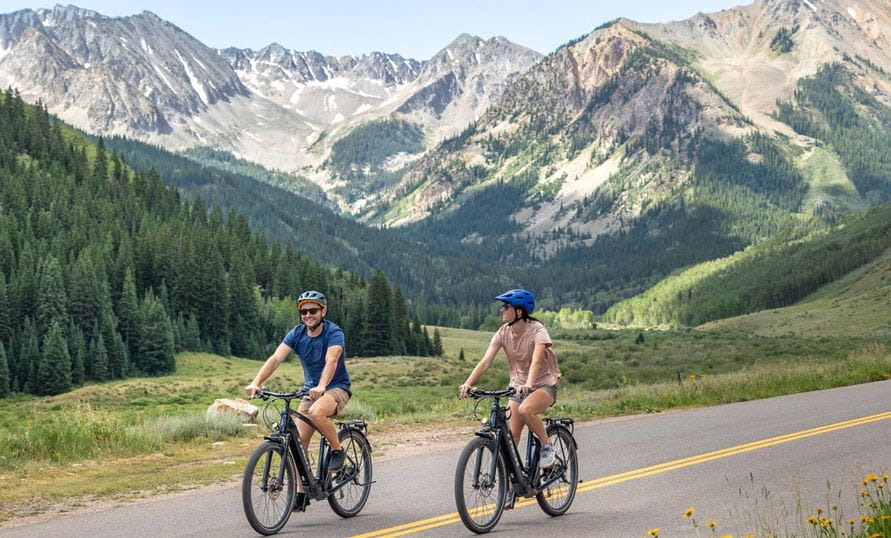 Two bikers road biking in Aspen during summer