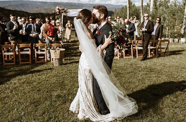 Couple kisses after wedding recessional at Snowmass