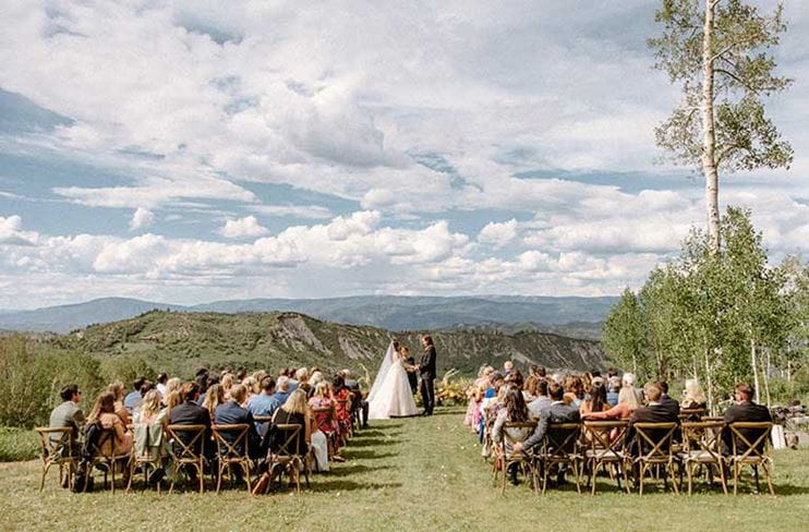 People attend a wedding ceremony at Lynn Britt Cabin
