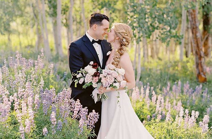 Couple kisses in a meadow of wildflowers at Snowmass