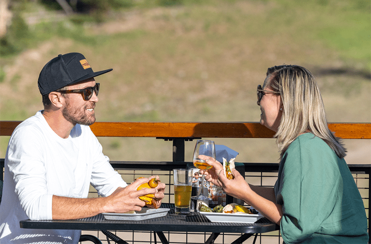 Couple enjoys a sunny day at the Elk Camp restaurant, having a bite to eat