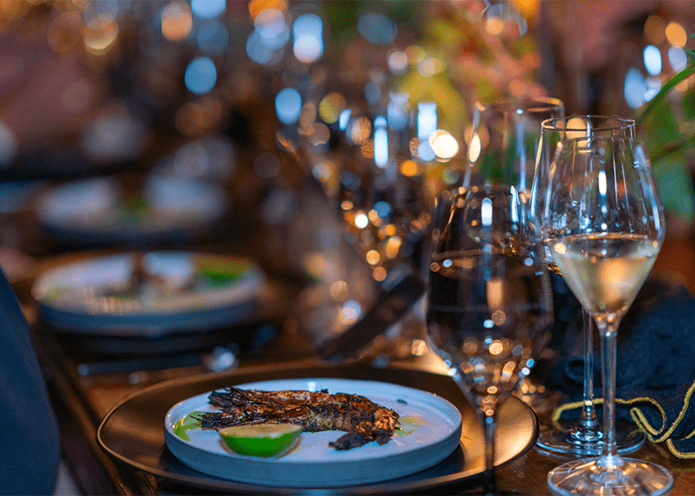 Close up, artistic shot of delicately plated meals with full glass of white wine in front, at Aspen Food and Wine Festival