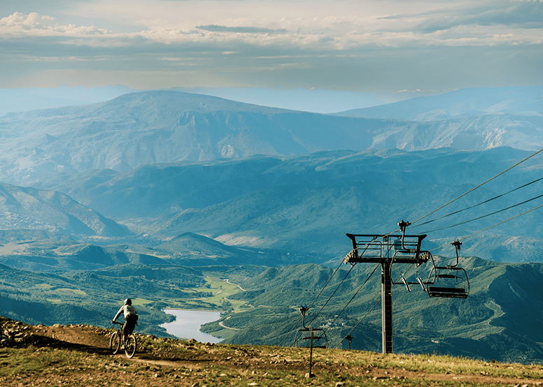 solo mountain bikers rides on a single trail high above the Snowmass Valley, at the top of Snowmass