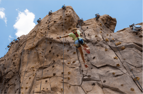 Kids climb on Lost Forest climbing wall at Snowmass