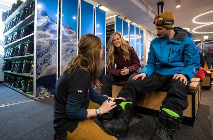 Two skiers get fitted for ski boots at Four Mountain Sports
