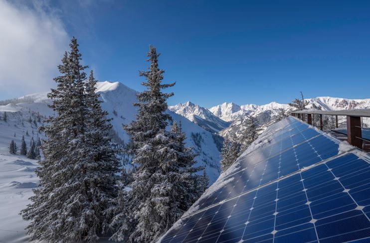 Solar powers atop Highlands with Maroon Bells in the distance in winter