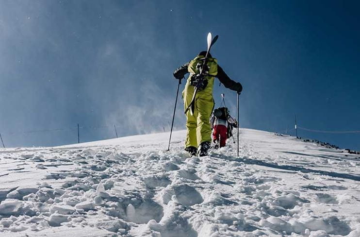 A skier climbs Highland Bowl