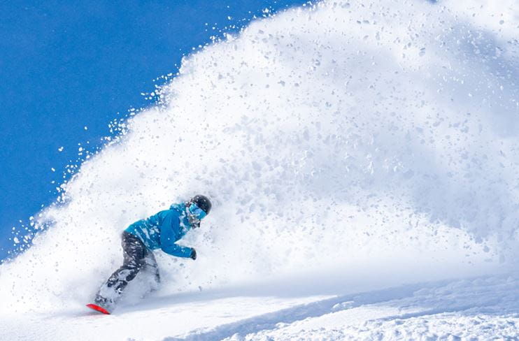 Snowboarder carving serious powder at Snowmass