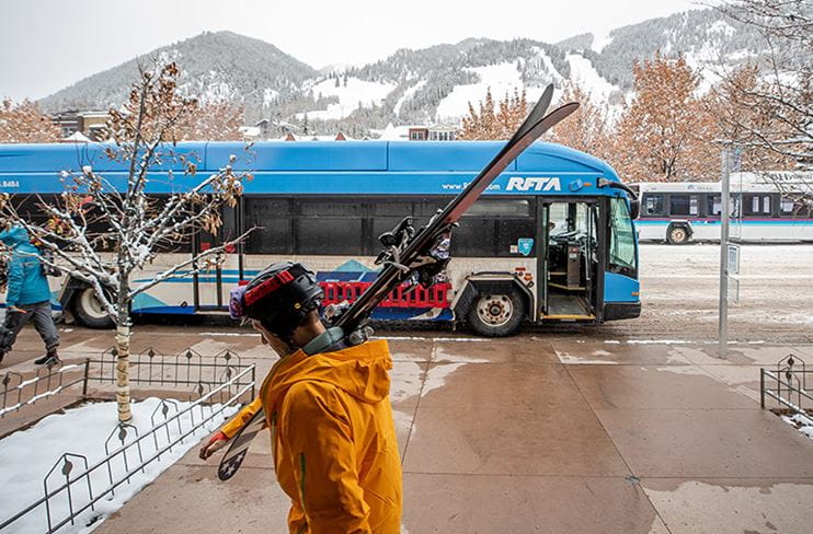 A skier walks by the RFTA bus terminal in Aspen