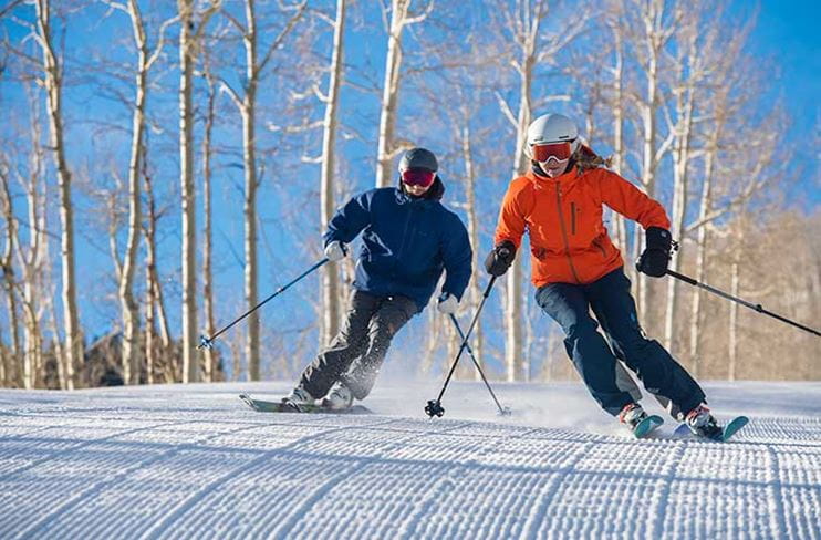 Two skiers enjoy their rental ski gear