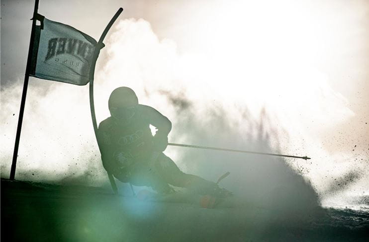 A Giant Slalom skier backlit during a race at Aspen Snowmass