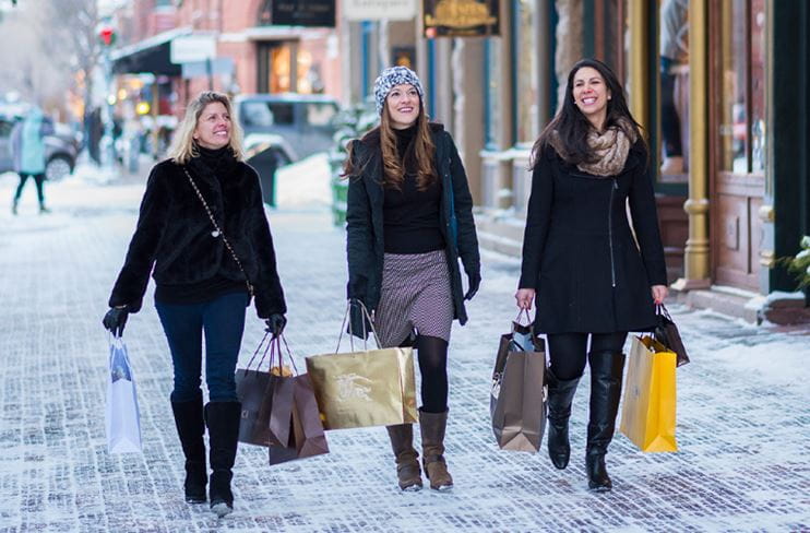 Three women strolling the sidewalk while shopping in downtown Aspen