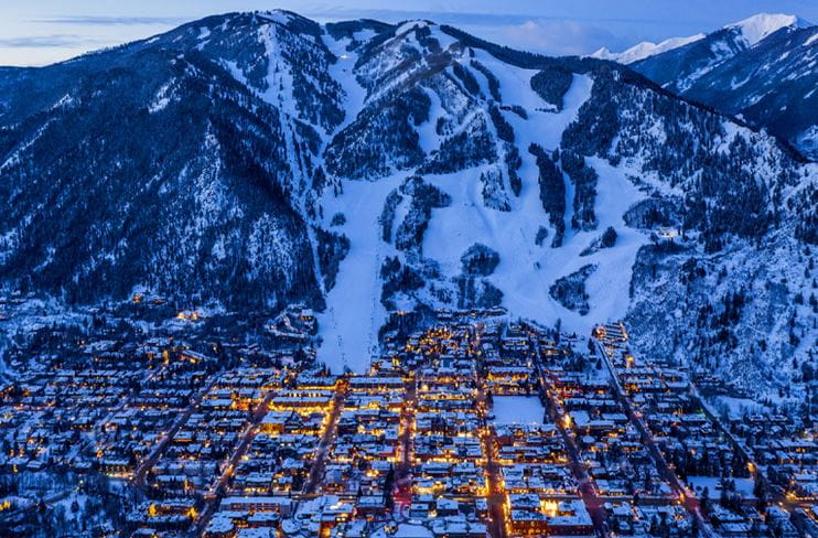 Downtown Aspen lit at dusk with Aspen Mountain in the distance