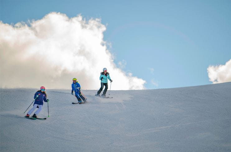 Three skiers on a perfect groomer at Aspen Snowmass