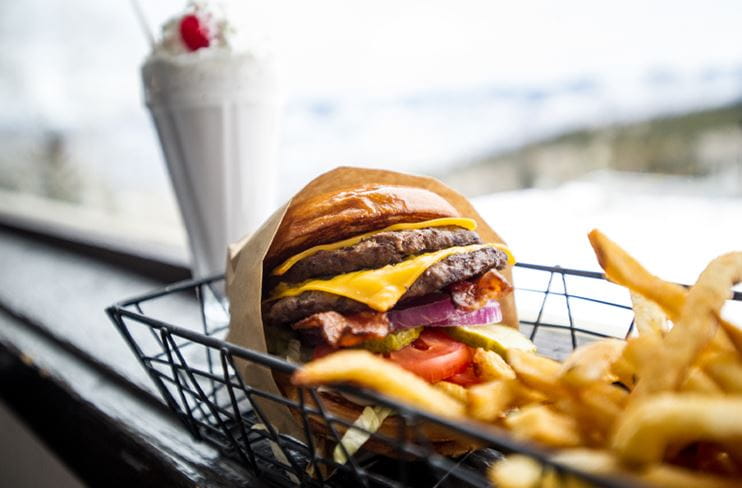 A juicy hamburger and fries with a shake