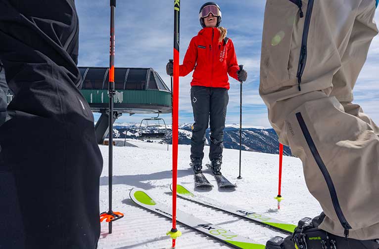 An Aspen Snowmass ski school instructor laughs with her clients
