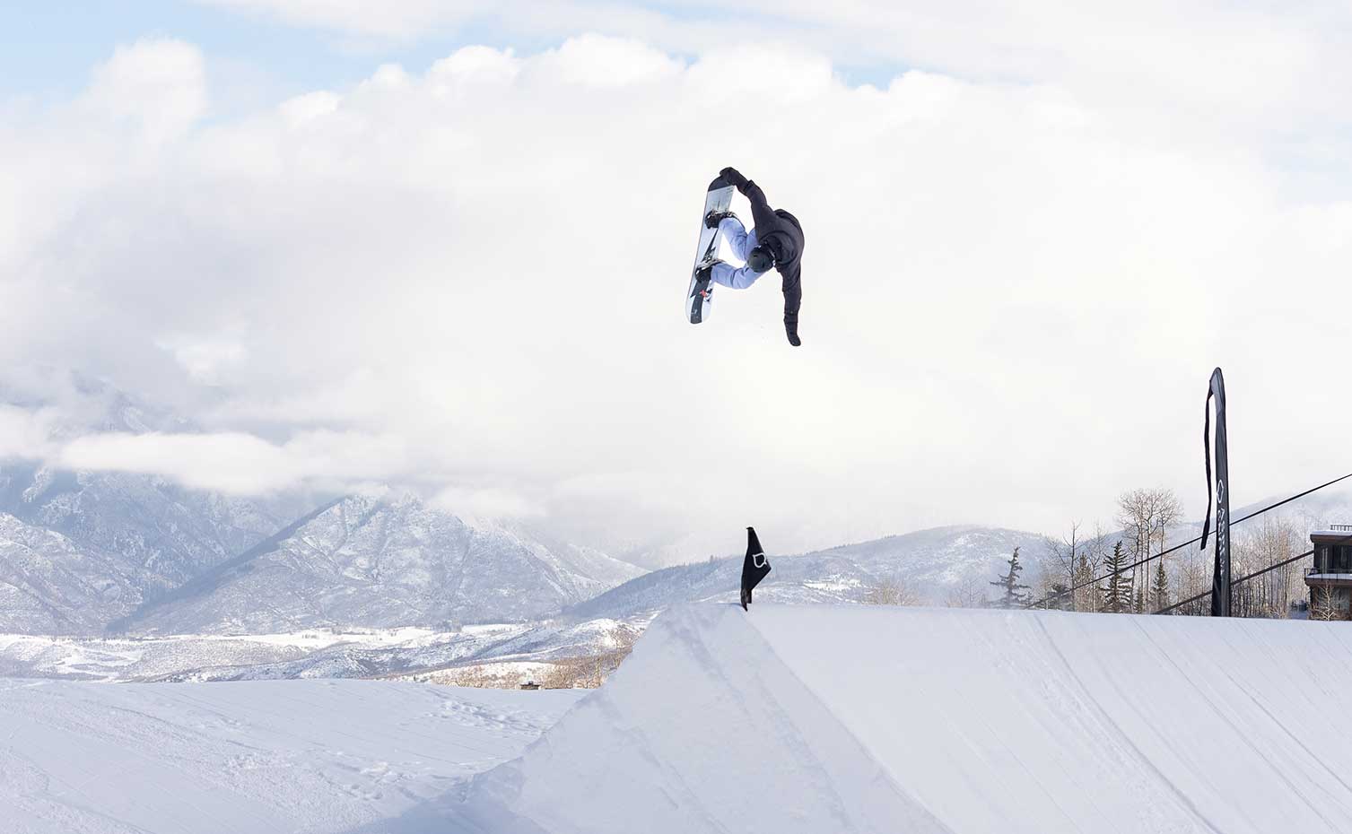 A snowboarder lifts off a berm at Snowmass' S3 Terrain Park
