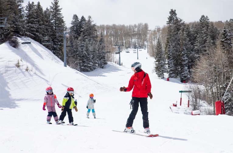 a group of children skiing on a snowy hill