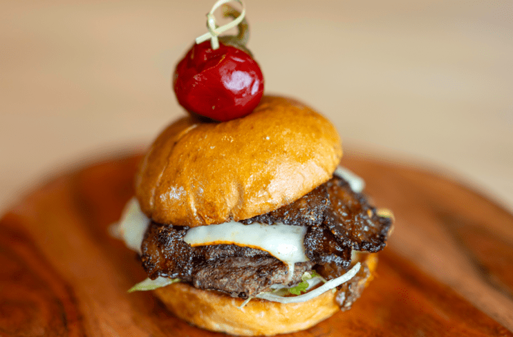 a burger with a cherry on top