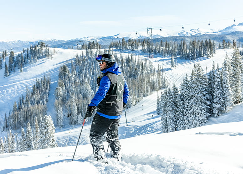 Aspen Snowmass employee stands looking over the Aspen Mountain