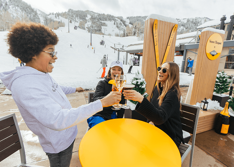 Three people cheers at Ajax Tavern after a long day of skiing on Aspen Mountain