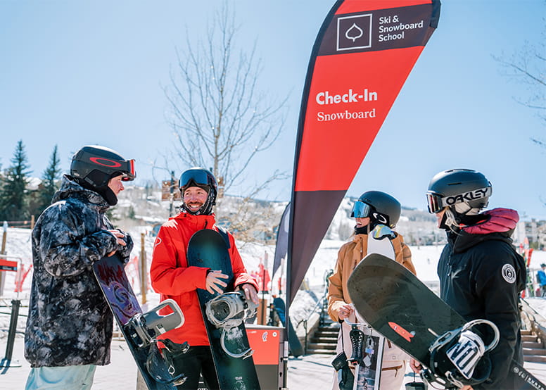 Group of boarders gather around Aspen Snowmass Pro to start their lesson