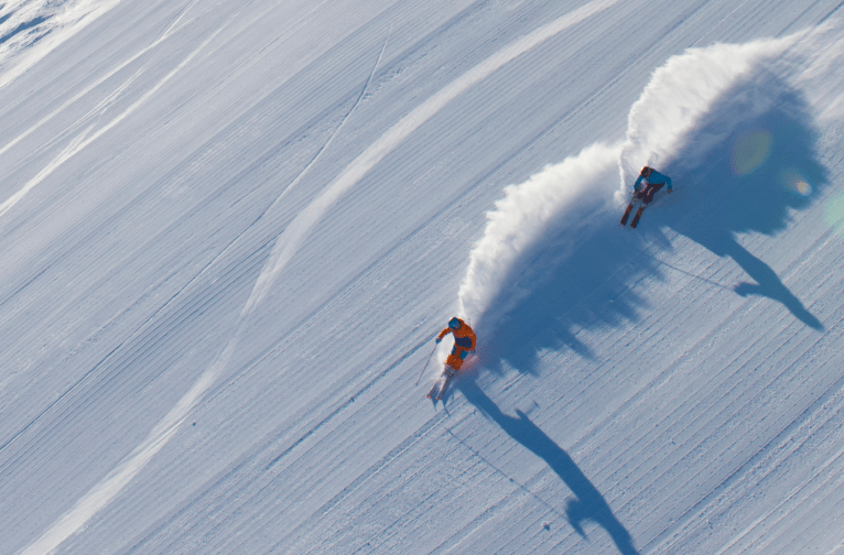 Drone photo of two skiers on a groomed trail at Aspen Snowmass