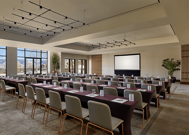 large meeting room at snowmass viceroy, red tables with gray chairs all facing the front of the room