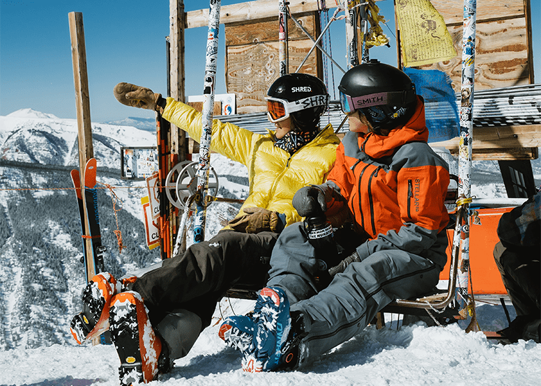 Two people sit at the top of the bowl, looking out over the expansive view