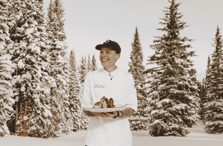 Chef Emily Oyer smiles in the snowy trees
