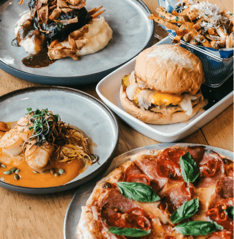 Plates of food at Limelight aspen, fresh pizza, burgers, parmesan fries, etc.