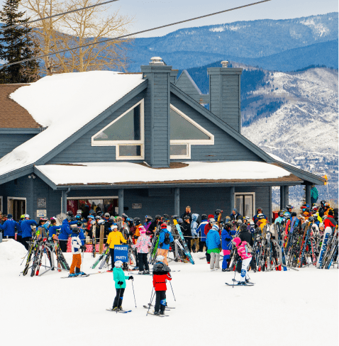 exterior view of Sider Sabich group building at Snowmass, people gather outside for The Hot Doggers hot dogs