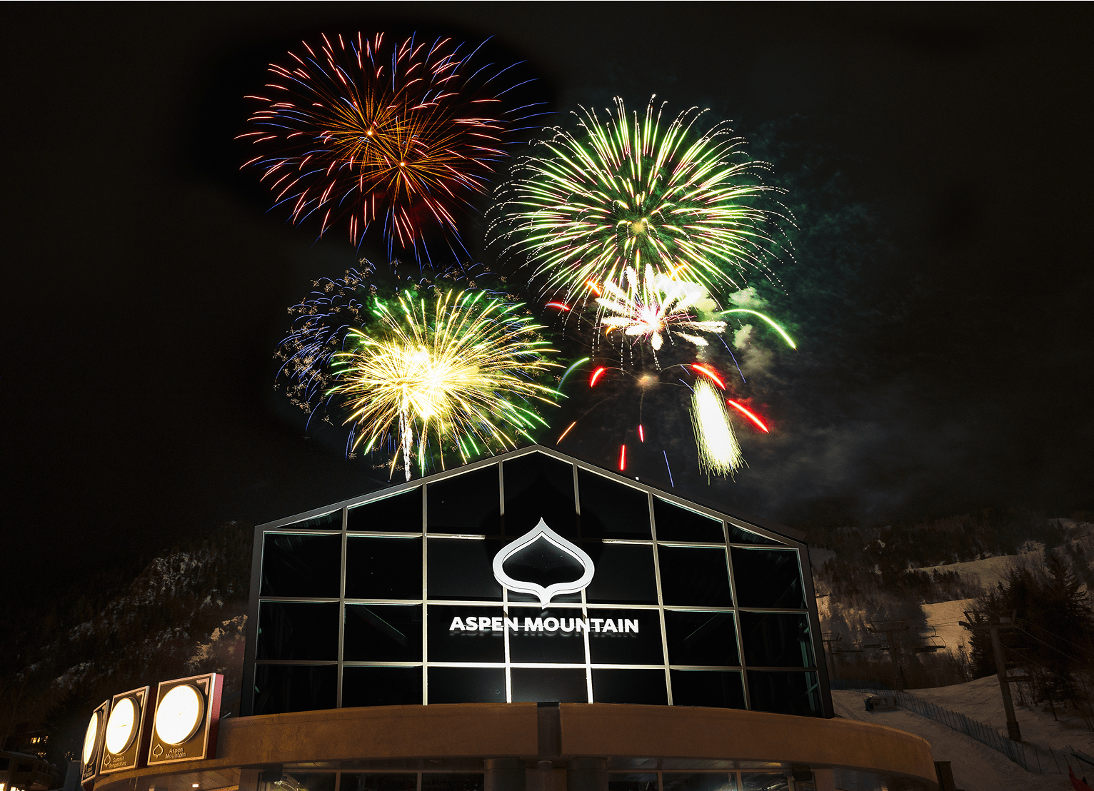 Fireworks over Gondola Plaza, black sky illuminated by green and red fireworks