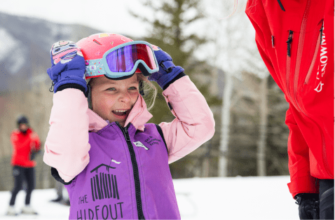 Little girl in her Aspen ski lesson pulls her goggles down