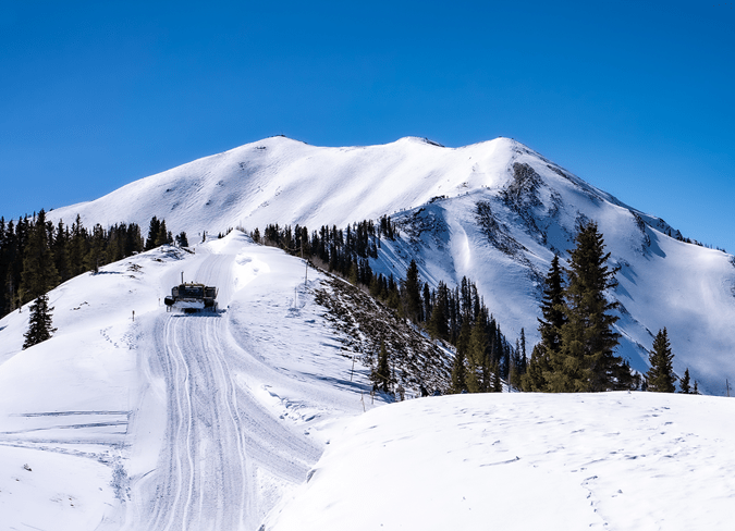 Snowcat drives up the foot path leading to the Aspen Highlands Bowl, driving people up to the base of the hike