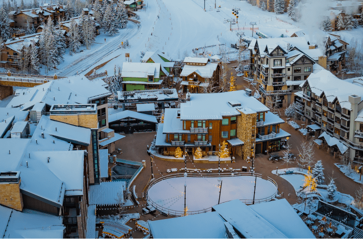 The base of Snowmass ski resort, hotels and restaurants cast a warm glow on the snowy winter sidewalks