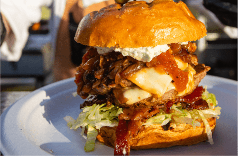 Close up of chicken sandwich between two toasted buns with fresh lettuce and tomatoes  