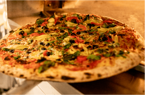 freshly baked pizza with veggies, pepperoni and crispy crust at Up 4 Pizza at Snowmass Ski Resort