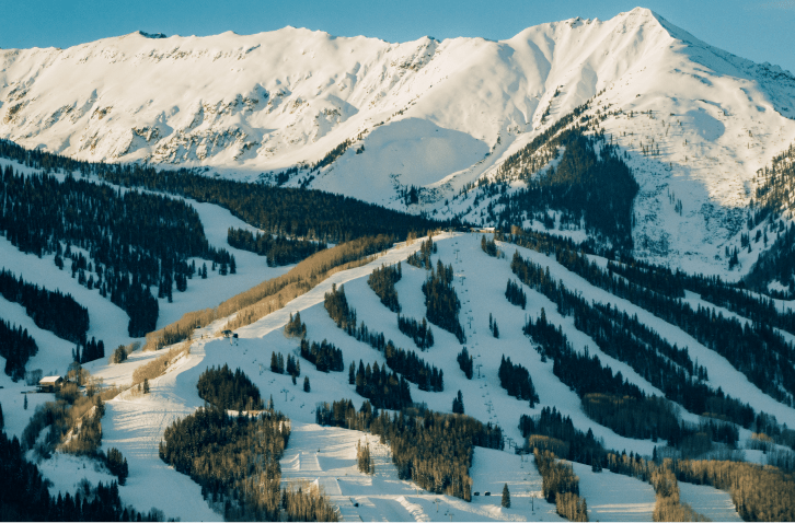 Aerial view of snowmass as sun casts golden glow on snowy slopes