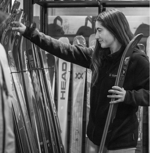 black and white image of woman replacing skies at four mountain sports