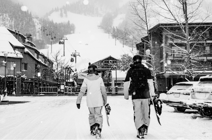 two people walk down the snowy streets, image in black and white
