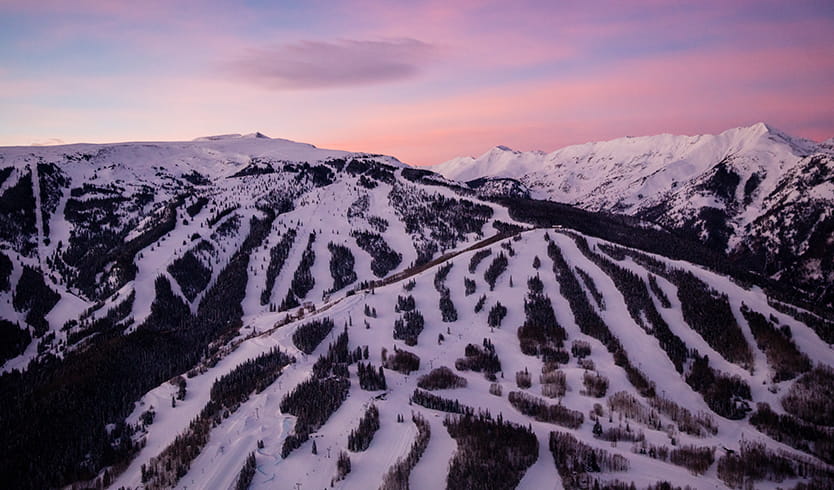 Aerial view of Snowmass at dusk with a vibrate pink sky. 