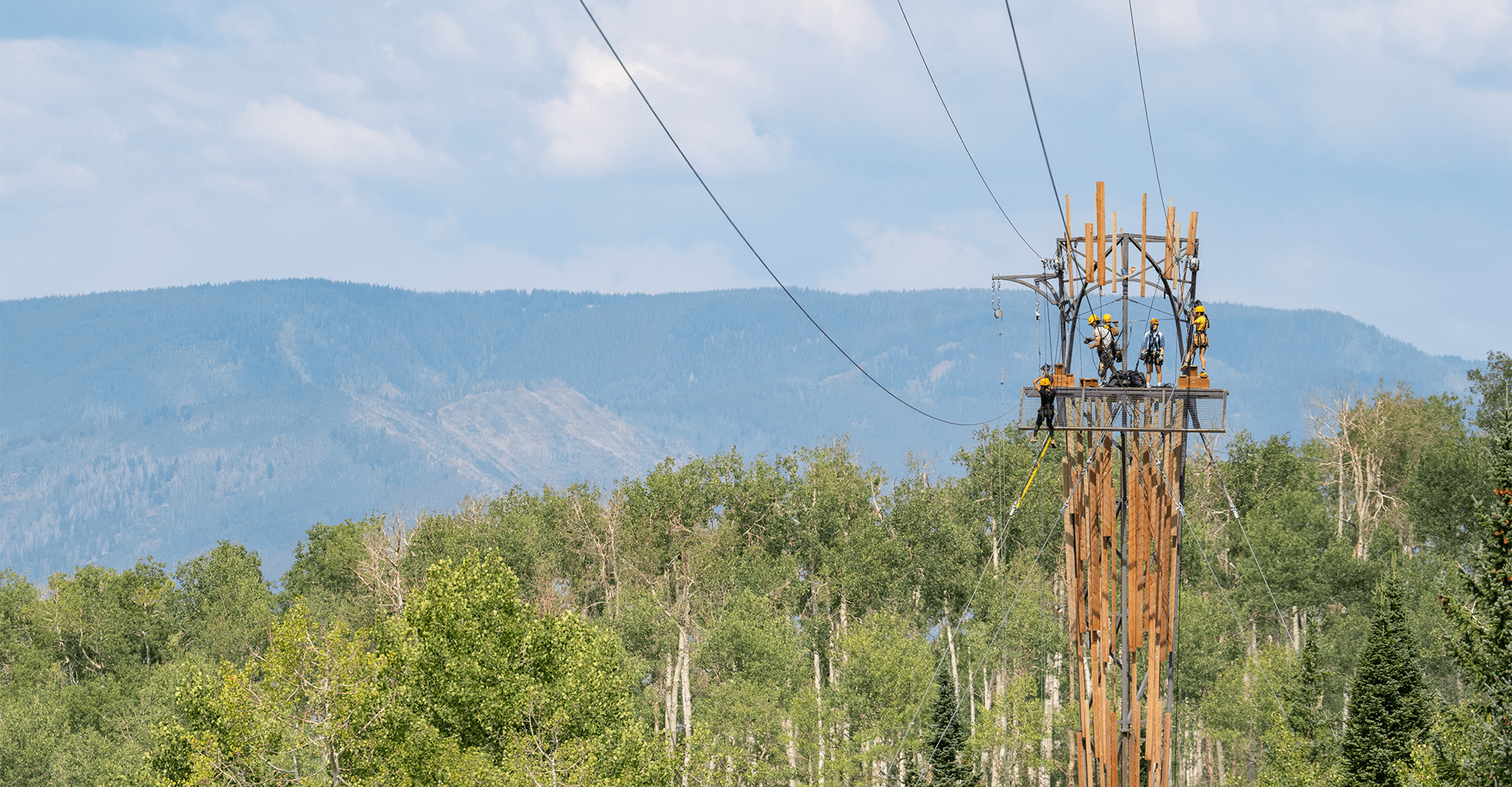 Long view of zipline tower, high above the ground, at Snowmass Lost Forest